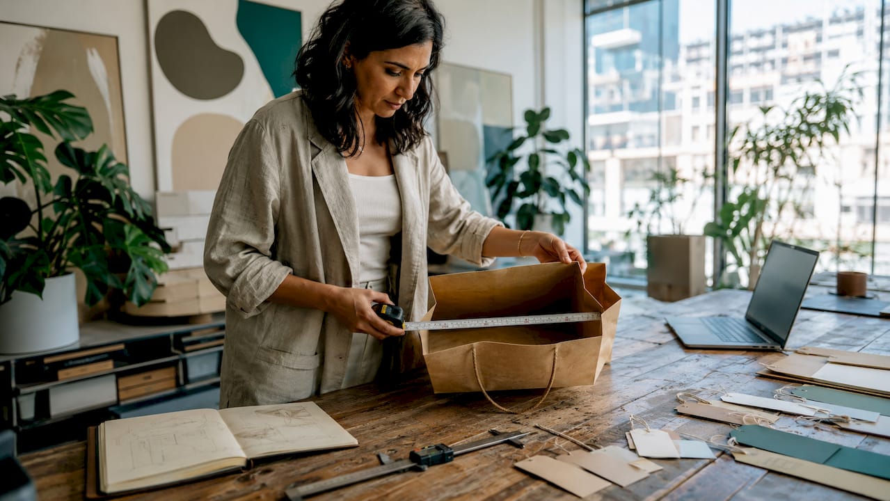 Product manager measuring paper bag internal size