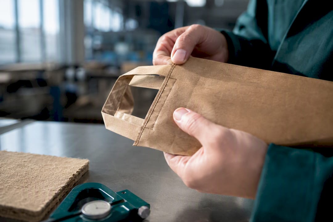 Technician inspecting paper bag handle attachment