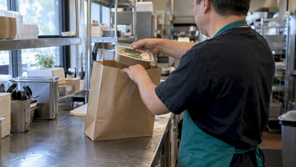 Paper takeout bag beside prepared food container